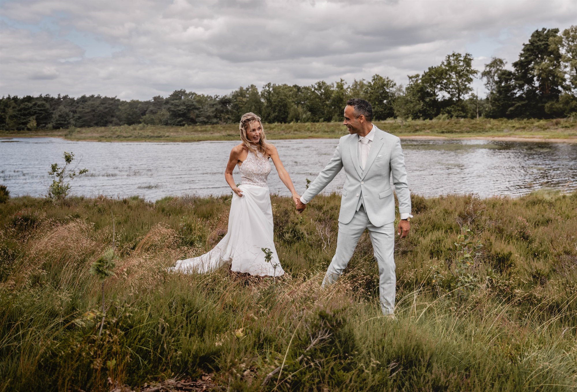 Bruidspaar wandelt langs het water in Drenthe